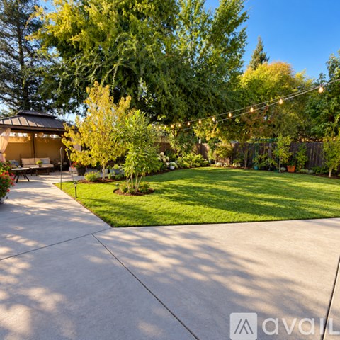A backyard with a patio and a gazebo.