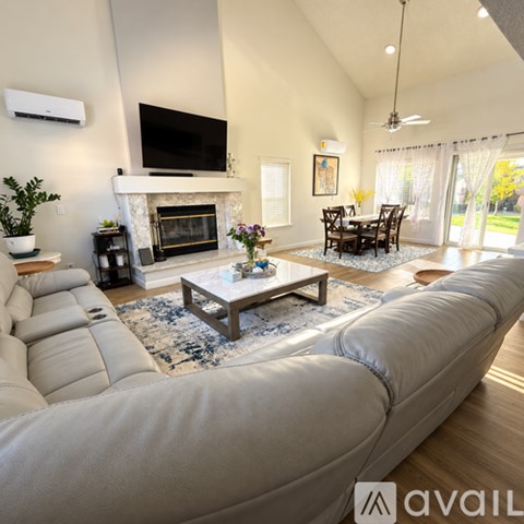 A living room with a white couch and a fireplace.