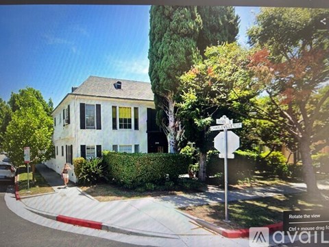 A white house with a black roof and a sign that says "Hillcrest".