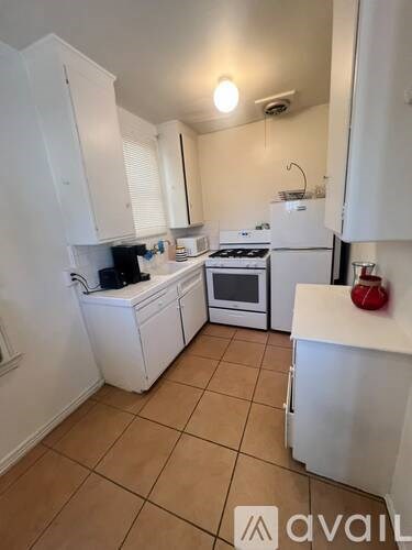 A kitchen with white appliances and cabinets.