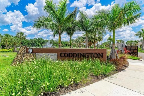 A sign that says Coddington in front of some trees.