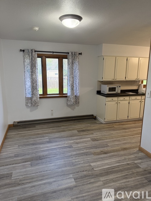 A kitchen with wooden floors and white walls.