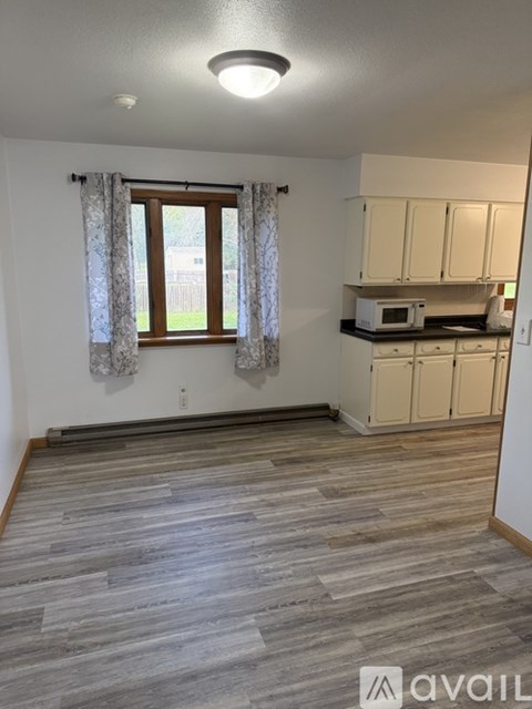 A kitchen with wooden floors and white walls.