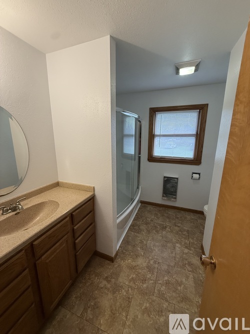 A bathroom with a sink, mirror, and tiled floor.