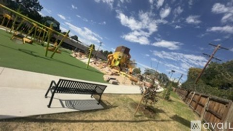 A playground with a swing set and a bench.