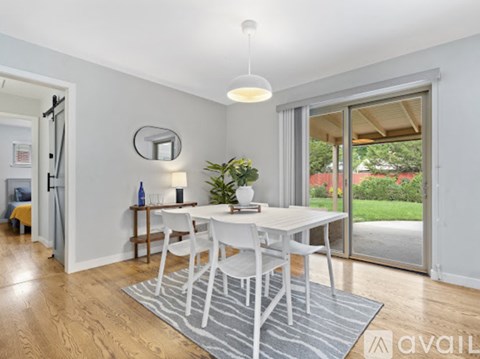 A dining room with a white table and chairs.