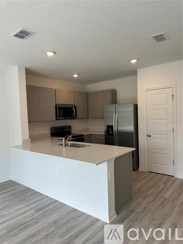 A kitchen with a white countertop and a refrigerator.