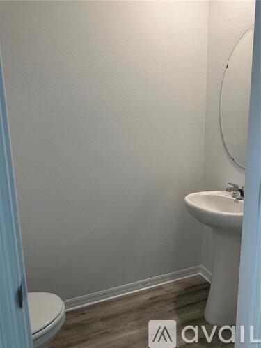 A bathroom with a toilet, sink, and mirror.