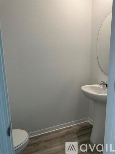 A bathroom with a toilet, sink, and mirror.