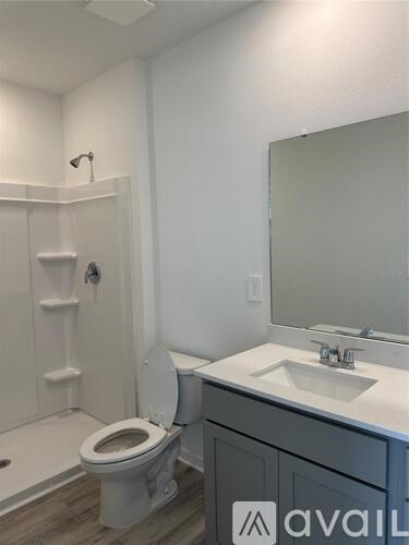 A bathroom with a toilet, sink, and mirror.