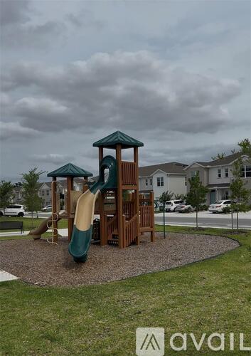 A playground with a green and brown slide and a yellow slide.