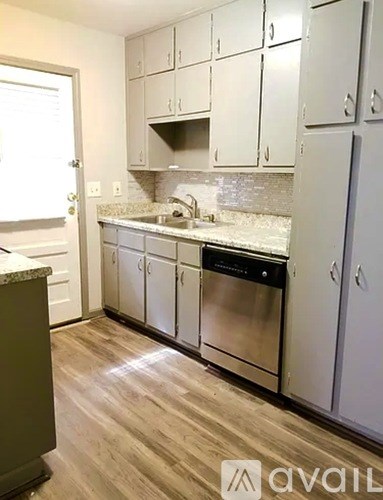 A kitchen with white cabinets and a stainless steel dishwasher.