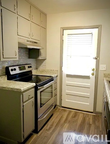 A kitchen with white cabinets and a black stove top oven.