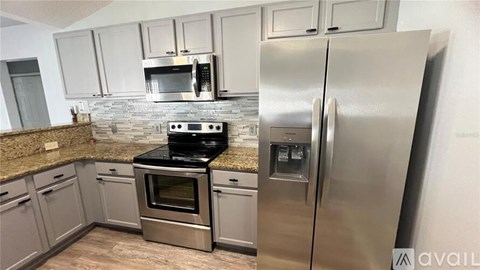 A kitchen with a stainless steel refrigerator and oven.