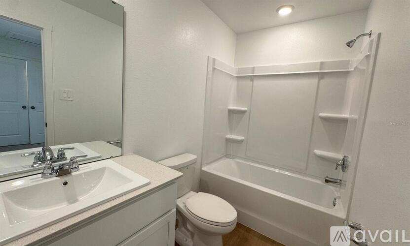 A white bathroom with a toilet, sink, and bathtub.
