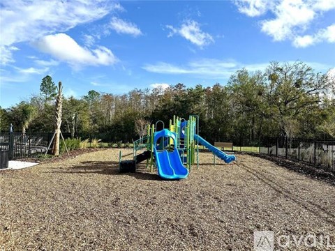 A playground with a blue slide and a green slide.