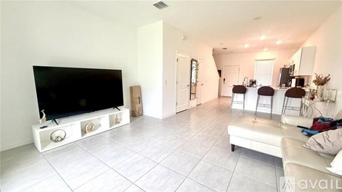 A living room with a flat screen TV and a white couch.