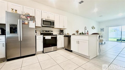 A kitchen with white cabinets and appliances.