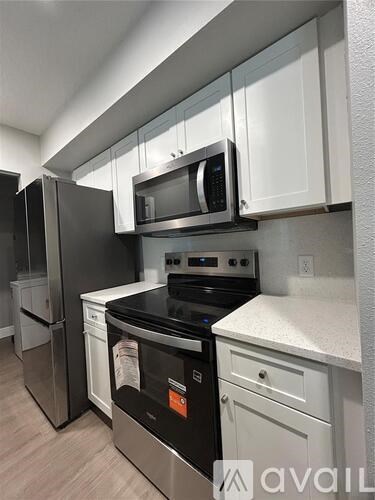 A kitchen with a black stove top oven and a black microwave above it.