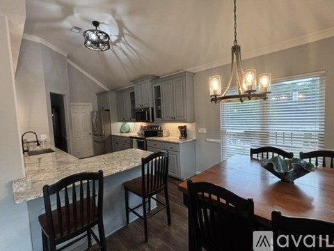 A kitchen with a table and chairs in front of a window.