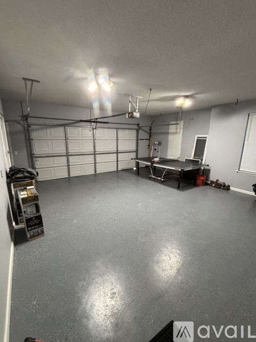 A spacious garage with a workbench and storage unit.