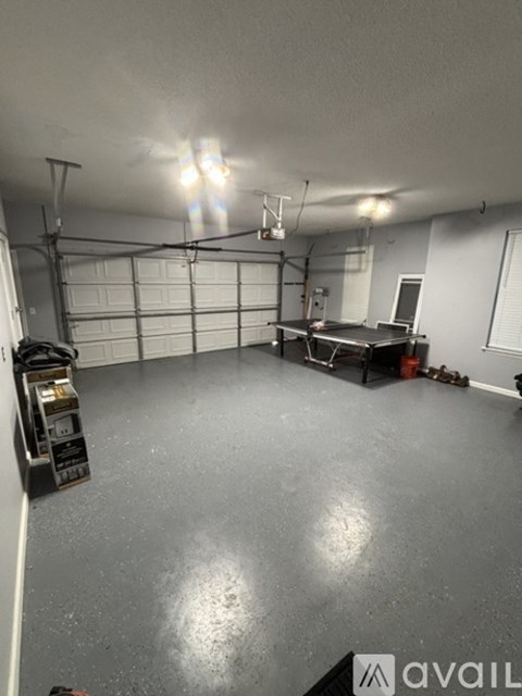 A spacious garage with a workbench and storage unit.