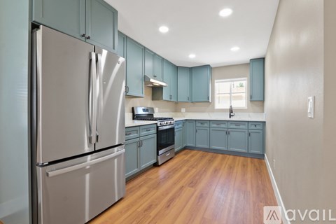 A kitchen with a refrigerator, oven, and cabinets.