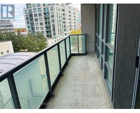 A balcony with glass railings and a view of a cityscape.