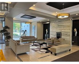 A well-lit living room with a large couch, a coffee table, and a fireplace.