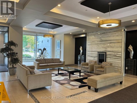 A well-lit living room with a large couch, a coffee table, and a fireplace.