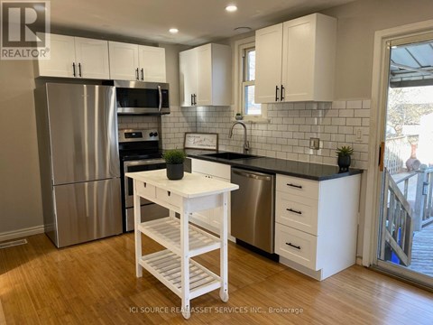 A kitchen with white cabinets and a black countertop.