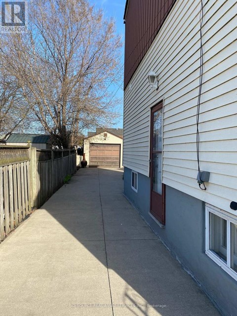 A long concrete walkway leads to a garage.
