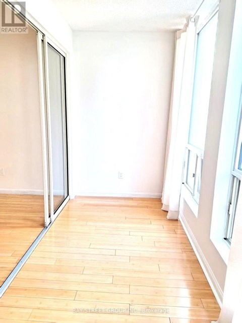 A room with a sliding glass door and wooden flooring.