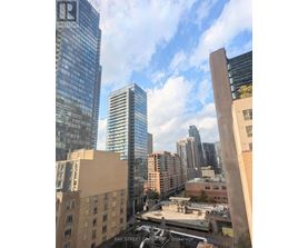 A cityscape with a mix of modern and older buildings, with a clear sky above.