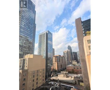 A cityscape with a mix of modern and older buildings, with a clear sky above.