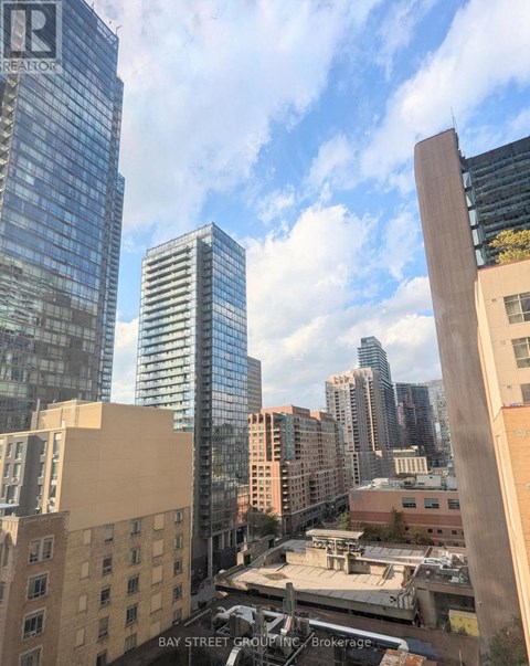 A cityscape with a mix of modern and older buildings, with a clear sky above.