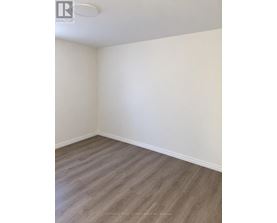 A room with wooden flooring and white walls.