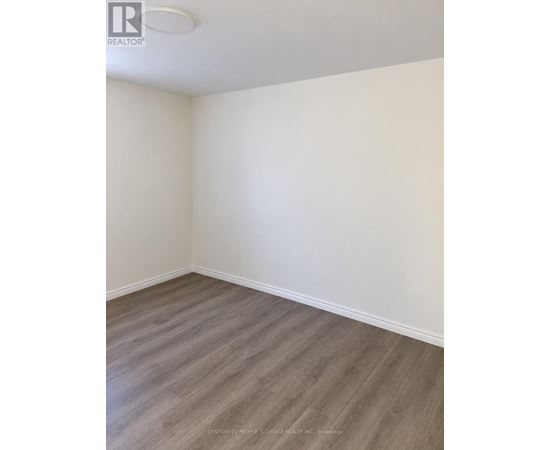 A room with wooden flooring and white walls.
