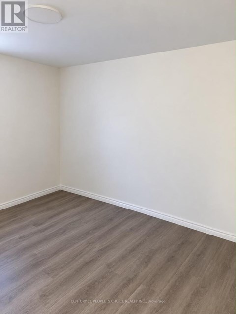 A room with wooden flooring and white walls.