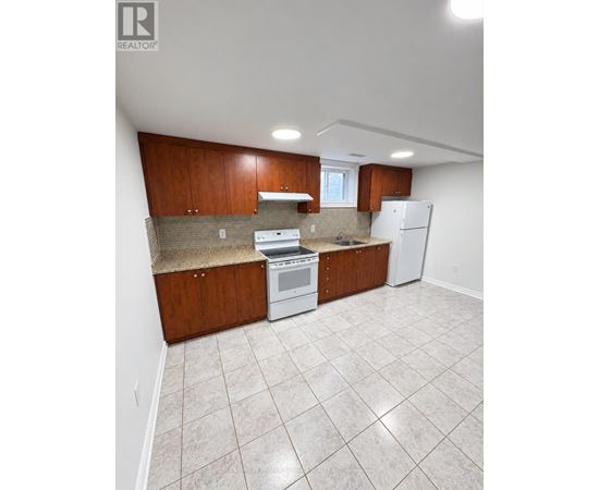 A kitchen with white appliances and brown cabinets.