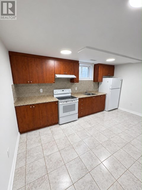 A kitchen with white appliances and brown cabinets.