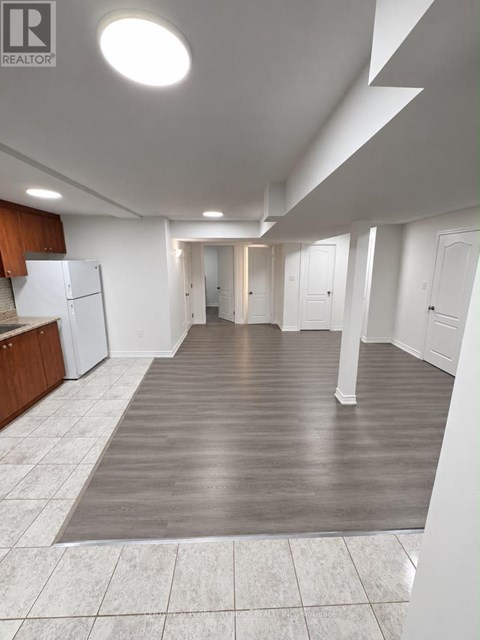 A large open room with a kitchen area and a hallway.