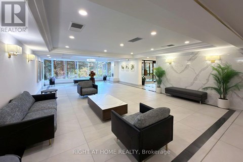 A spacious living room with a black couch and a coffee table.