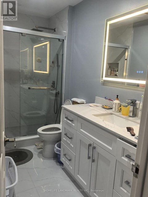 A bathroom with a toilet, sink, and mirror.