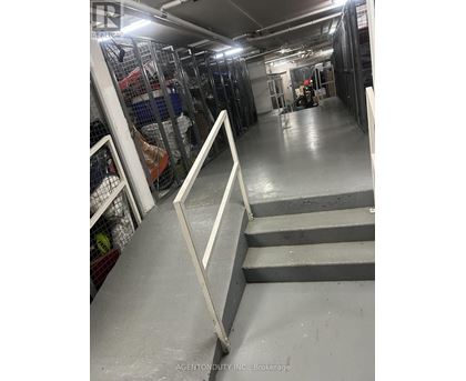 A long hallway with a metal railing on the left and a staircase on the right.