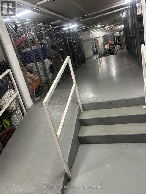 A long hallway with a metal railing on the left and a staircase on the right.