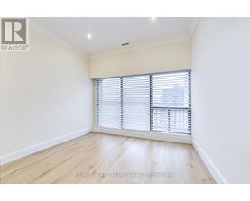 A room with a window covered by white blinds.