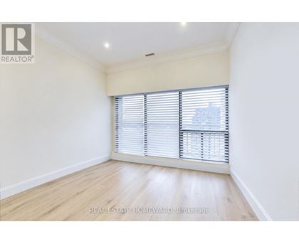 A room with a window covered by white blinds.