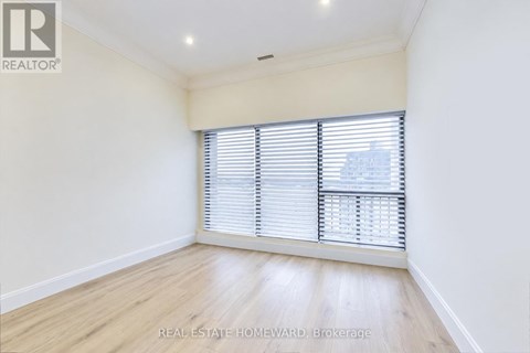 A room with a window covered by white blinds.