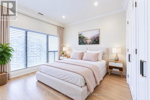 A bedroom with a large bed, a potted plant, and a painting on the wall.